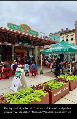 an outdoor market with people sitting at tables and plants at CUTE & COZY/TQL stadium/ Findlay Market/Brewery in Cincinnati