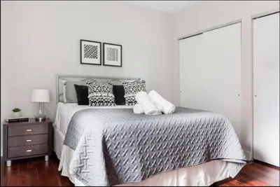 a white bedroom with a large bed with pillows at CUTE & COZY/TQL stadium/ Findlay Market/Brewery in Cincinnati