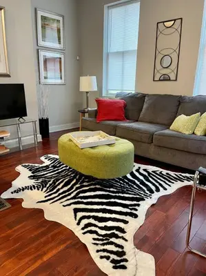 a living room with a zebra rug and a couch at CUTE & COZY/TQL stadium/ Findlay Market/Brewery in Cincinnati