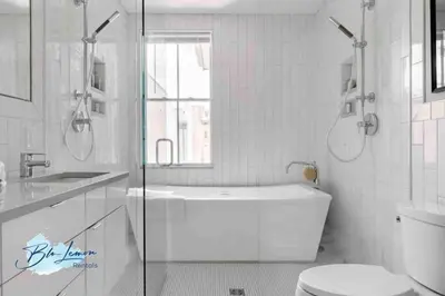 a white bathroom with a tub and a toilet at This property is unlisted in Cincinnati