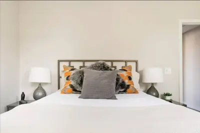a bedroom with a white bed with two lamps at This property is unlisted in Cincinnati