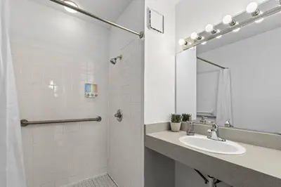 a white bathroom with a sink and a mirror at Deluxe 5-bedroom Walk everywhere in Over the Rhine in Cincinnati