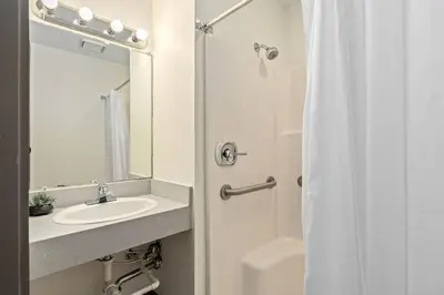 a bathroom with a sink and a shower with a mirror at Deluxe 5-bedroom Walk everywhere in Over the Rhine in Cincinnati