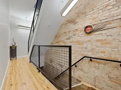 a brick wall with a staircase in a room at Luxury 4-Bedroom Retreat in the Heart of Over the Rhine in Cincinnati