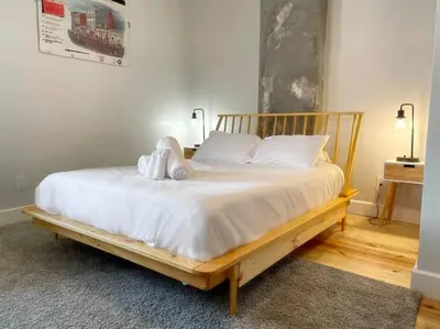 a bedroom with a wooden bed with white sheets at Luxury 4-Bedroom Retreat in the Heart of Over the Rhine in Cincinnati