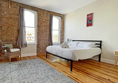 a bedroom with a bed and a brick wall at Luxury 4-Bedroom Retreat in the Heart of Over the Rhine in Cincinnati