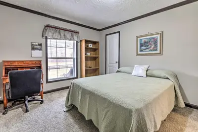 a bedroom with a bed and a desk and a chair at Lovely Sadieville Retreat with Deck and Grill! in Corinth