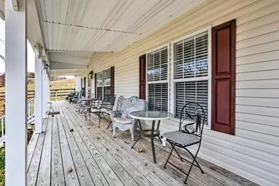 a porch with chairs and a table on a house at Lovely Sadieville Retreat with Deck and Grill! in Corinth