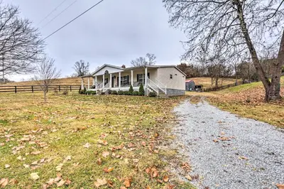a white house in a field with a gravel road at Lovely Sadieville Retreat with Deck and Grill! in Corinth