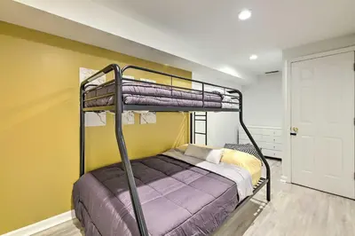 a bedroom with a bunk bed and a yellow wall at Luxury Maineville Villa with Private Pool and Deck in Maineville