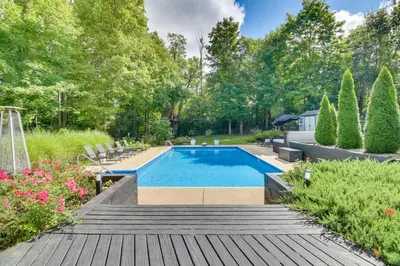 a swimming pool in a yard with a wooden deck at Luxury Maineville Villa with Private Pool and Deck in Maineville