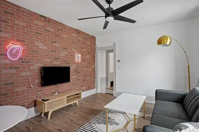 a living room with a couch and a brick wall at Center of Little Italy #4 in Cleveland