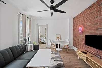 a living room with a couch and a brick wall at Center of Little Italy #4 in Cleveland