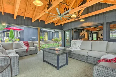 a living room with couches and a fire pit at Riverfront Zanesville Getaway with Private Bar! in Dresden