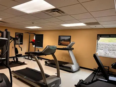 a gym with a treadmill and ellipticals in a room at Ambridge Inn in Ambridge