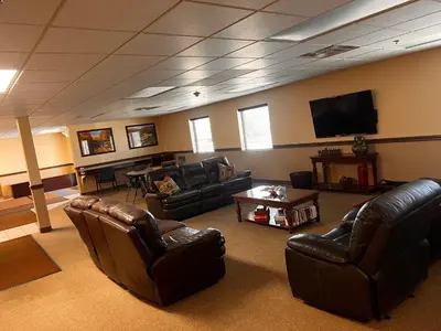a living room with leather furniture and a flat screen tv at Ambridge Inn in Ambridge