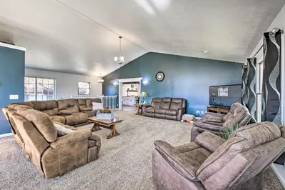 a large living room with couches and a tv at Spacious Massillon Log Cabin with Fire Pit! in Massillon