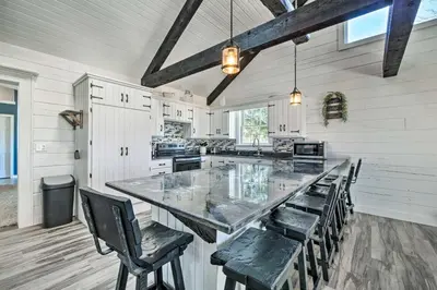 a large kitchen with a large table and chairs at Spacious Massillon Log Cabin with Fire Pit! in Massillon