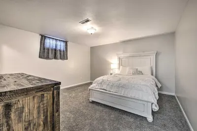 a bedroom with a white bed and a window at Spacious Massillon Log Cabin with Fire Pit! in Massillon