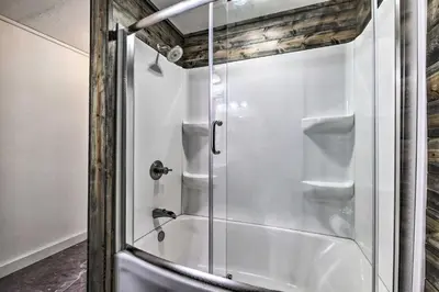 a shower with a glass door in a bathroom at Spacious Massillon Log Cabin with Fire Pit! in Massillon