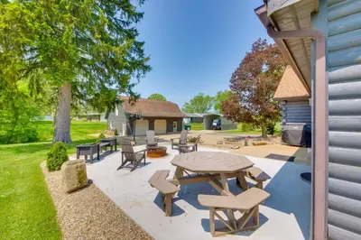 a patio with a table and chairs in a yard at Spacious Massillon Log Cabin with Fire Pit! in Massillon