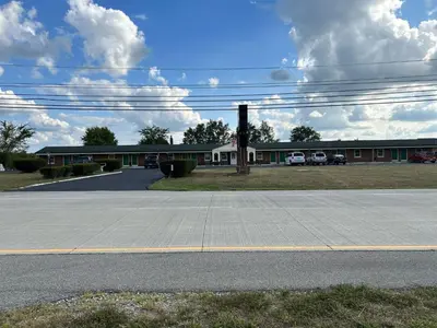 an empty parking lot in front of a building at Hillcrest Motel by Oyo Aurora near Lawrenceburg in Aurora