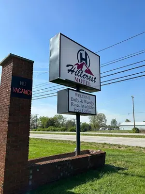 a sign for a marauder motel next to a street at Hillcrest Motel by Oyo Aurora near Lawrenceburg in Aurora