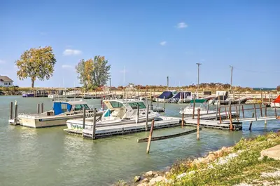 a group of boats docked at a dock in the water at Quaint Couples Escape Pool, Near Lake Erie! in Oak Harbor