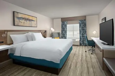 a hotel room with a bed and a desk and a television at Hilton Garden Inn Florence Cincinnati Airport South in Florence