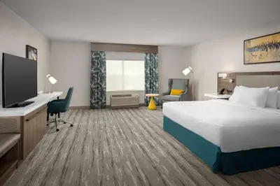 a hotel room with a bed and a flat screen tv at Hilton Garden Inn Florence Cincinnati Airport South in Florence