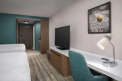 a hotel room with a bed and a desk with a television at Hilton Garden Inn Florence Cincinnati Airport South in Florence