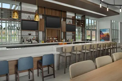 a bar in a restaurant with chairs and tables at Hilton Garden Inn Florence Cincinnati Airport South in Florence