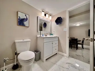 a bathroom with a toilet and a sink and a table at 7086 Tylersville Beautiful 4 BDR Home - Near I-75 in Maud