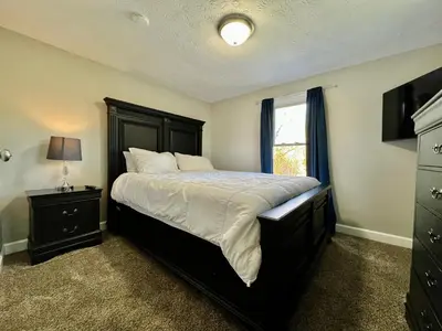 a bedroom with a large bed and a window at 7086 Tylersville Beautiful 4 BDR Home - Near I-75 in Maud
