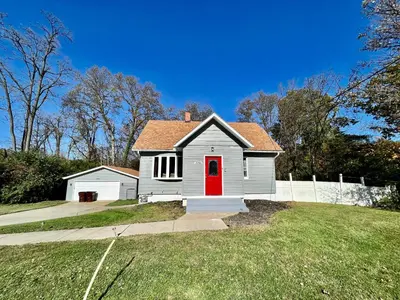 a white house with a red door in a yard at 7086 Tylersville Beautiful 4 BDR Home - Near I-75 in Maud