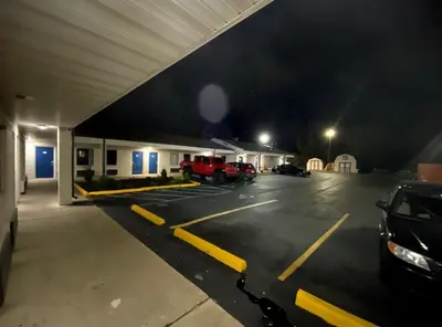 a parking lot with a car dealership at night at DELUXE INN in Erie