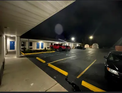 a parking lot with cars parked in front of a building at DELUXE INN in Erie