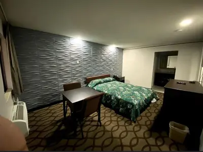 a hotel room with a bed and a table and a desk at DELUXE INN in Erie