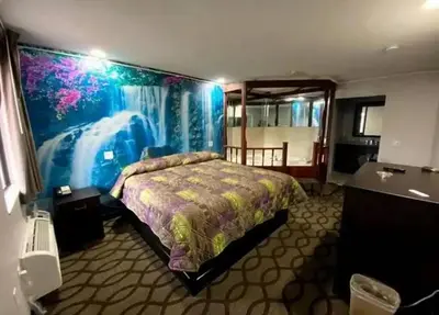 a bedroom with a bed with a painting on the wall at DELUXE INN in Erie