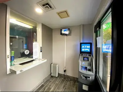 a gas station with a atm machine next to a window at DELUXE INN in Erie