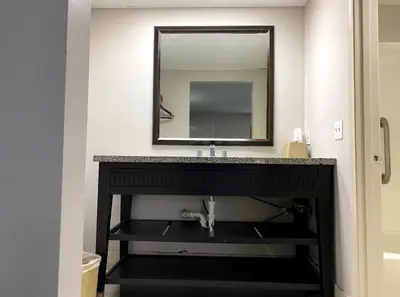 a bathroom with a sink and a mirror at DELUXE INN in Erie