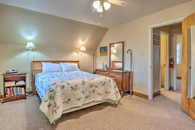 a bedroom with a bed and a dresser and a mirror at Riverside Cabin with 3 Decks in North Vernon! in North Vernon