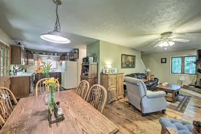 a kitchen and living room with a table and chairs at Riverside Cabin with 3 Decks in North Vernon! in North Vernon