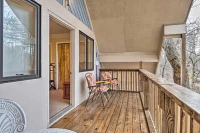 a balcony of a house with a table and chairs at Riverside Cabin with 3 Decks in North Vernon! in North Vernon