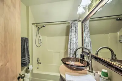 a bathroom with a sink and a shower with a tub at Riverside Cabin with 3 Decks in North Vernon! in North Vernon