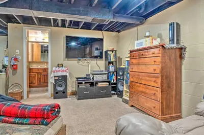 a living room with a dresser and other furniture at Riverside Cabin with 3 Decks in North Vernon! in North Vernon
