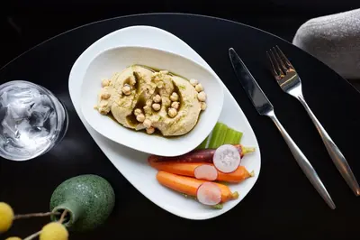 a plate of food with a bowl of hummus and vegetables at AC Hotel by Marriott Dayton in Dayton