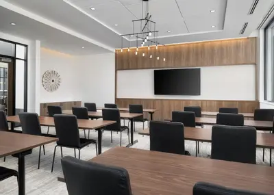 a conference room with tables and chairs and a projection screen at AC Hotel by Marriott Dayton in Dayton