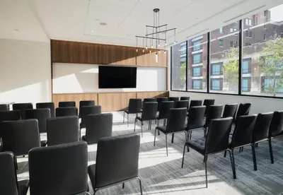 a conference room with black chairs and a flat screen tv at AC Hotel by Marriott Dayton in Dayton