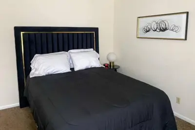 a bedroom with a large black bed with white pillows at 17 S First - Unit 6 17 s first street unit 6 in Trenton